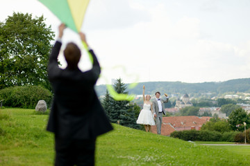 Bride and groom flying a kite on a wedding day