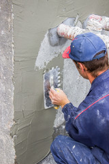 building worker spreading mortar on concrete wall 4