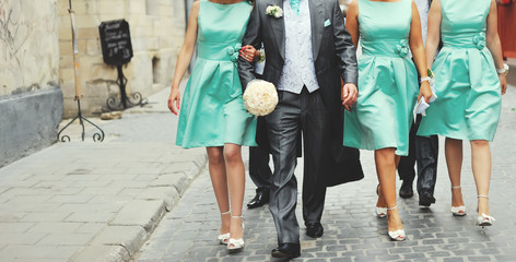 Groom and bridesmaid walking street.