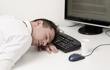 tired businessman sleeping on computer