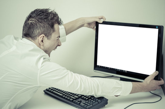 angry man grabbing his computer with a white screen