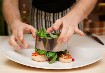 Chef is cooking appetizer with scallops
