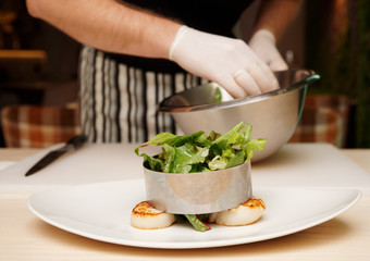 Chef is cooking appetizer with scallops