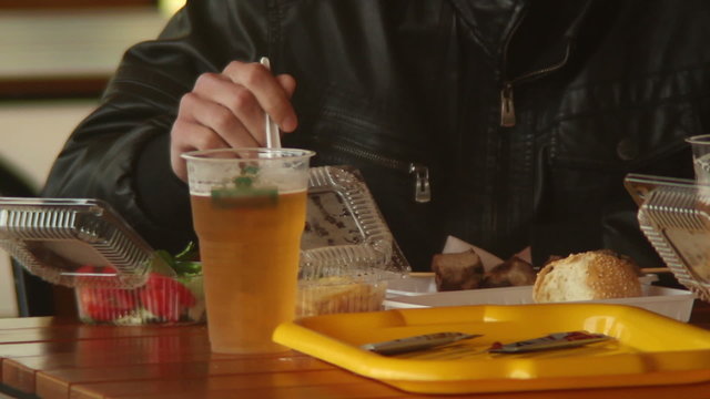Man in fastfood restaurant eating potato chips burgers meat beer