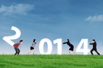 Businesspeople arrange new year 2014 outdoor