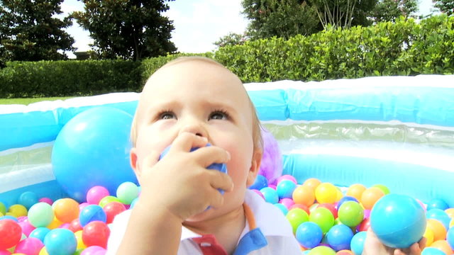 Smiling Little Boy Playing Plastic Ball Pool Outdoors 