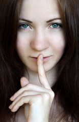 Naklejka premium Beautiful brunette makes warning sign with her finger