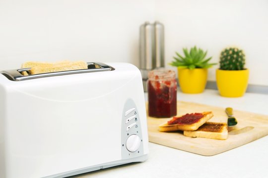 Breakfast prepare. Toaster and toast with jam in modern kitchen