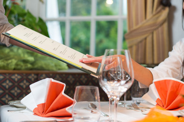 Woman in a restaurant choosing meal from menu
