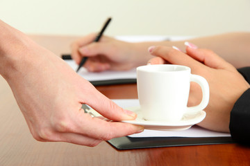 Fototapeta na wymiar Close up of businesswoman hands with cup of coffee during