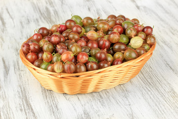 Fresh gooseberries in wicker basket on table close-up