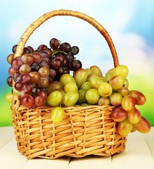 Fresh grape on wicker mat on bright background