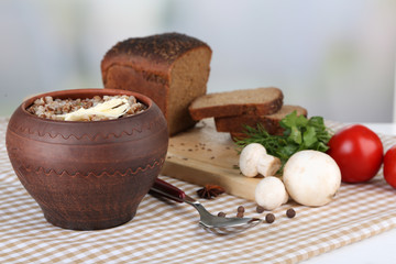 Buckwheat in pot with bread and vegetables closeup