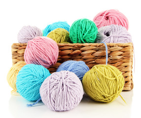 Multicolored clews in wicker basket isolated on white