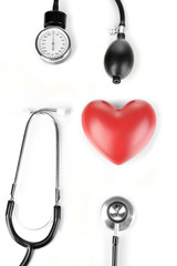 Tonometer, stethoscope and heart isolated on white