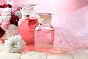 Obraz na płótnie Canvas Butelki szklane z kolorowym istocie, na różowym tle