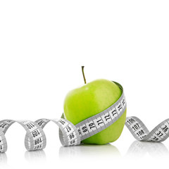 Measuring tape wrapped around a green apple