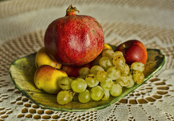 autumn grape, apple, pomegranate fruits in bowl