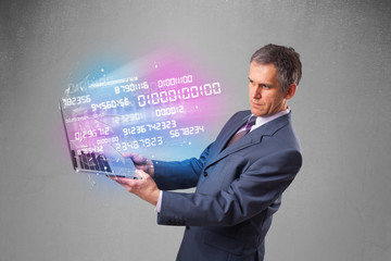 Businessman holding notebook with exploding data and numbers