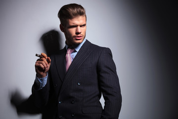 relaxed business man in a classic suit smoking a cigar
