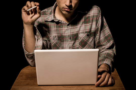 Cigarette smoking man working on laptop