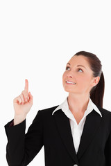 Gorgeous woman in suit pointing at a copy space