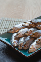 Fresh tasty raw sprats on serving dish