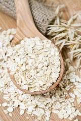 oat flakes in a spoon on wooden surface