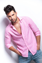 young fashion man holds hands in pockets