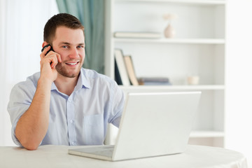 Smiling businessman on the phone in his homeoffice