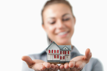 Close up of model house being held by female estate agent