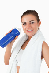 Smiling woman with her bottle after workout