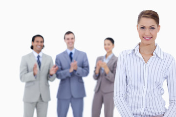 Close-up of a woman smiling with business people applauding