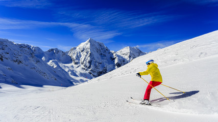 Ski, skier on ski run - woman skiing downhill