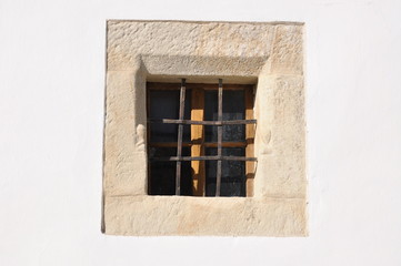 A small window on the facade of the old building