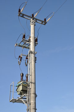 Electric pole with a transformer on a background of blue sky