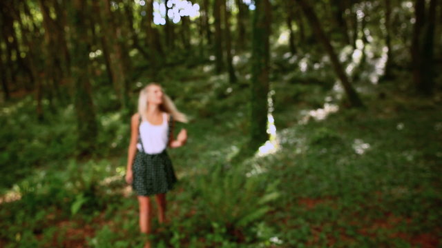 Attractive blonde walking through forest