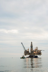 Fototapeta na wymiar Oil rig being tugged in the sea