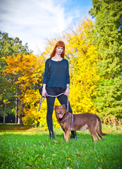 Elegant woman has fun with her big dog in the park