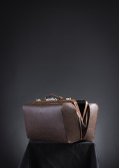 Brown vintage valise on a dark background.