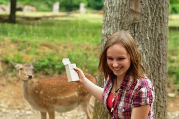 Woman feeding a deer in a wild park