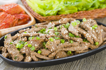 Bulgogi - Korean grilled beef with side dishes and lettuce