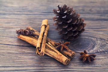 Star anise, cinnamon and pine cone on a wooden background