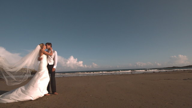 Happy bridal couple kissing on the beach