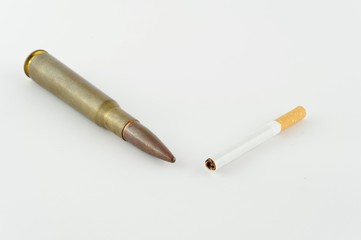 Cigaret and cartridge from fire-arms, it is isolated on a white