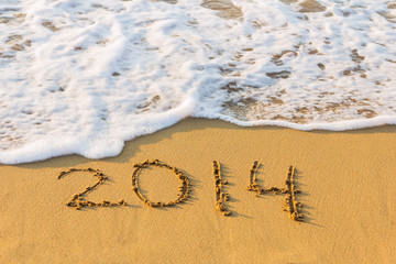 New Year 2014 is coming concept. Inscription 2014 on beach sand.
