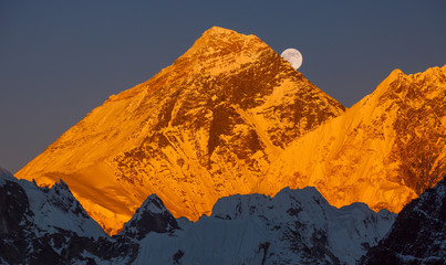 Gold pyramid of Mount Everest (8848 m) at sunset. Ascending moon