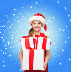 girl in santa helper hat with many gift boxes