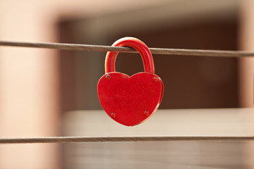 closeup of red love lock hanging on brige