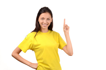 Beautiful girl with yellow t-shirt pointing up.